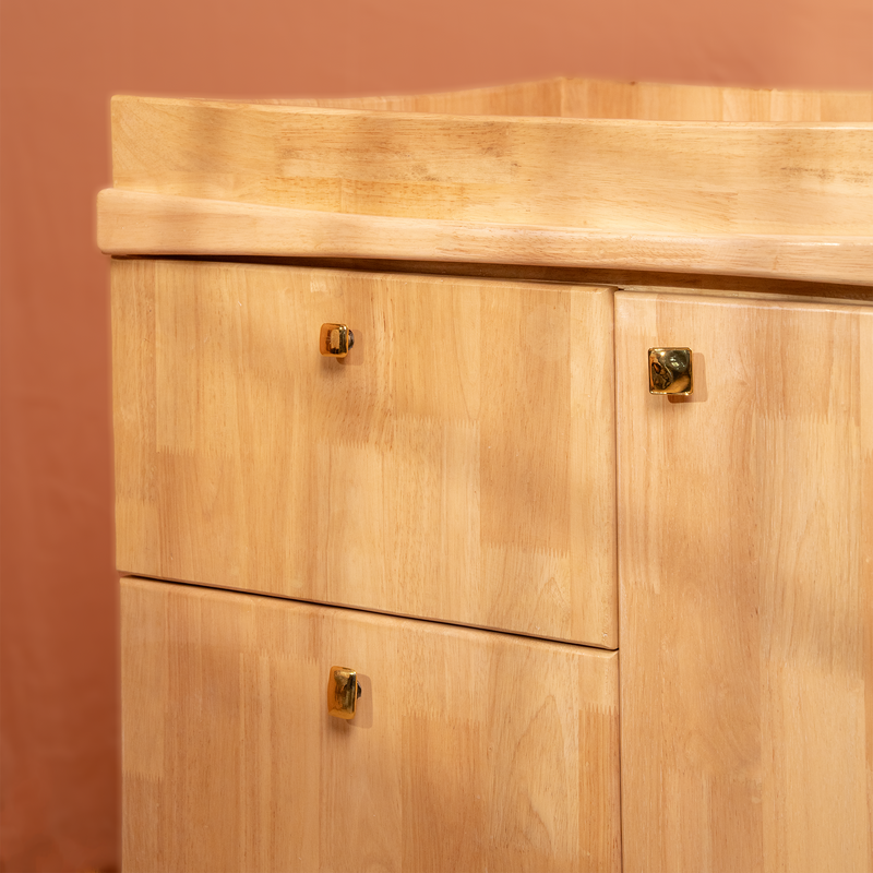 Wooden cabinet with two doors and two drawers against a brown wall.