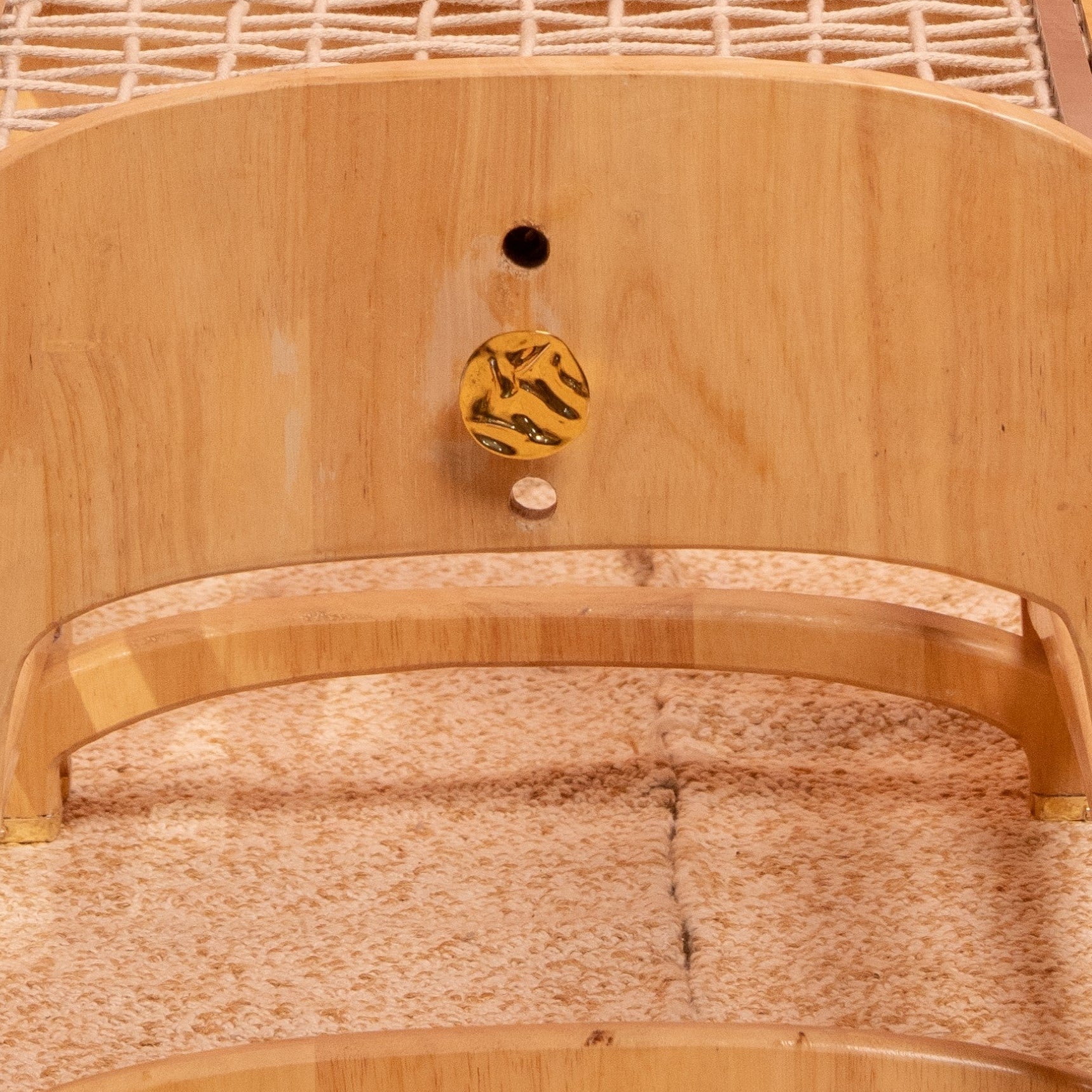 Caste brass unique knob on natural wood.