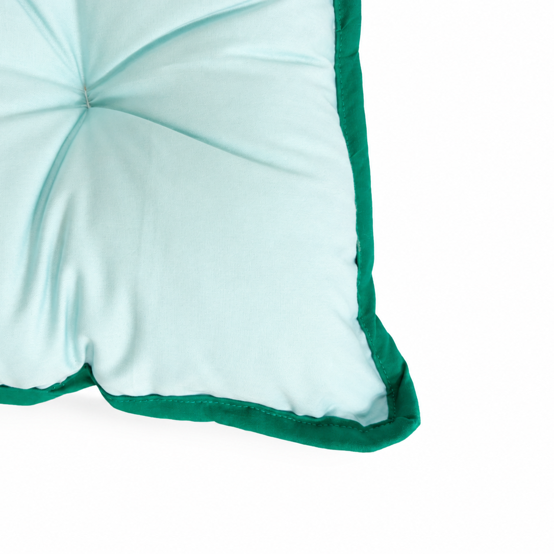 Light blue cushion with green trim on a white background